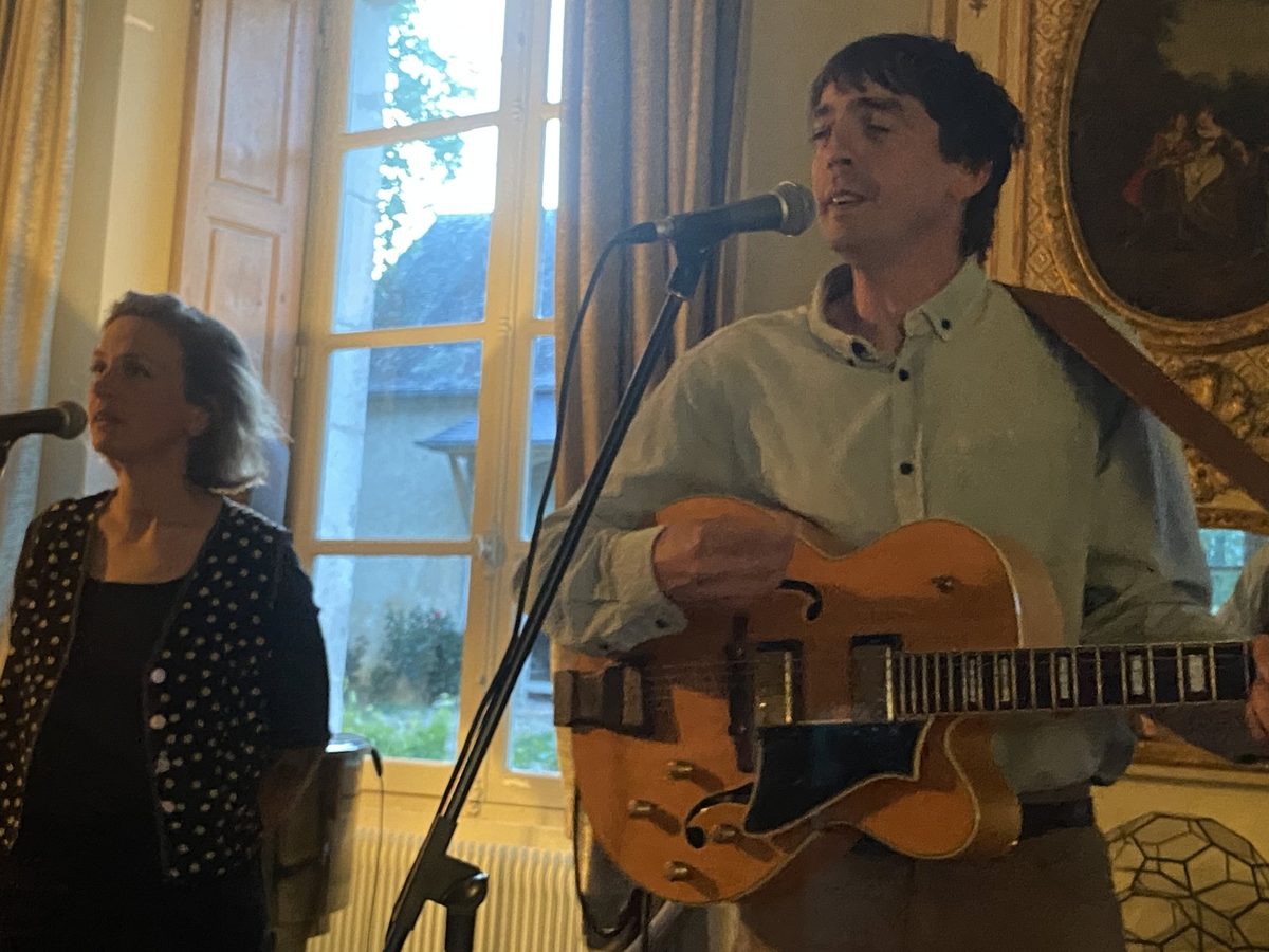 Un duo chant et guitare devant la fenêtre du salon